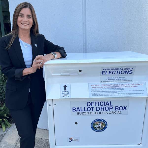 City Clerk standing next to a ballot box
