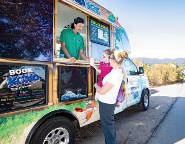 Kona Ice serving shaved ice to a mom and child
