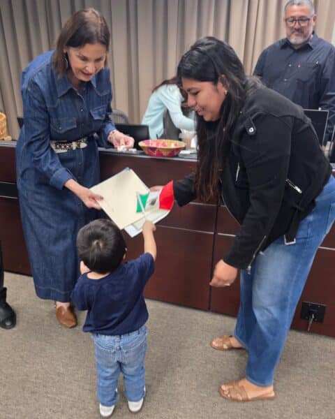 Mayor presenting documents to a little boy at dual citizenship event on Oct. 10, 2026